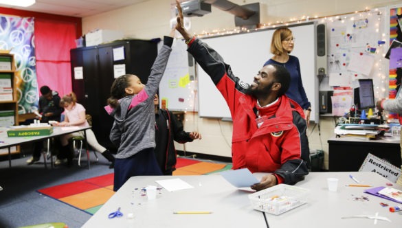 City Year AmeriCorps member high five with student