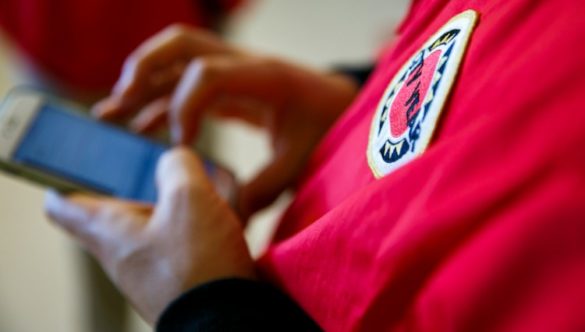 closeup of someone in a red jacket holding a mobile phone