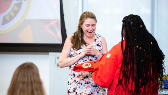 New Board member Lily Maxwell receives her City Year red jacket at the corps Graduation ceremony