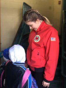 Annika Bell greets students as they arrive at Wilson