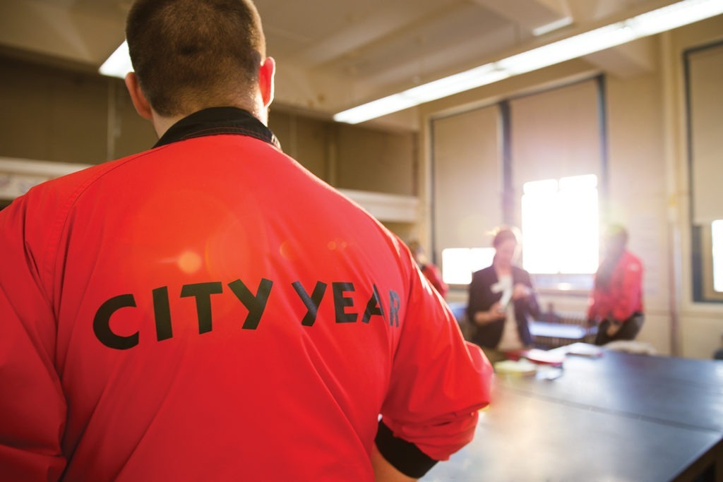 City Year AmeriCorps members planning with a teacher in a classroom