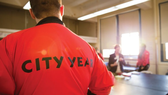 City Year AmeriCorps members planning with a teacher in a classroom