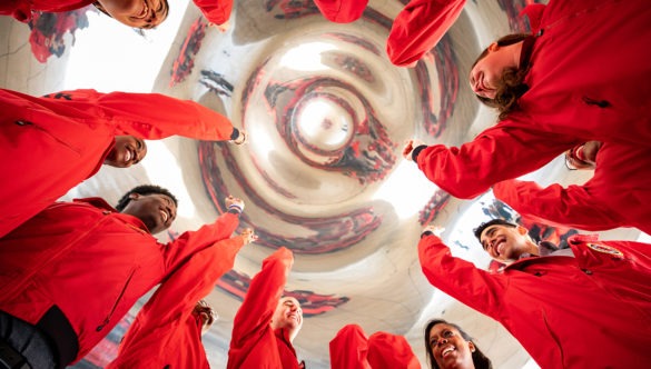 Twelve AmeriCorps members with their arms up in a spirit break