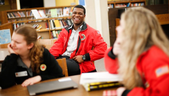 Three AmeriCorps members in the library planning together