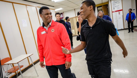 AmeriCorps member walking and laughing with a high school student