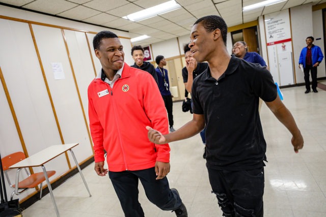 AmeriCorps member walking and laughing with a high school student