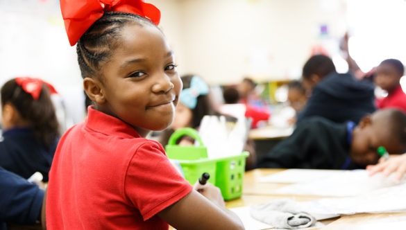 a student turns around from their work to smile