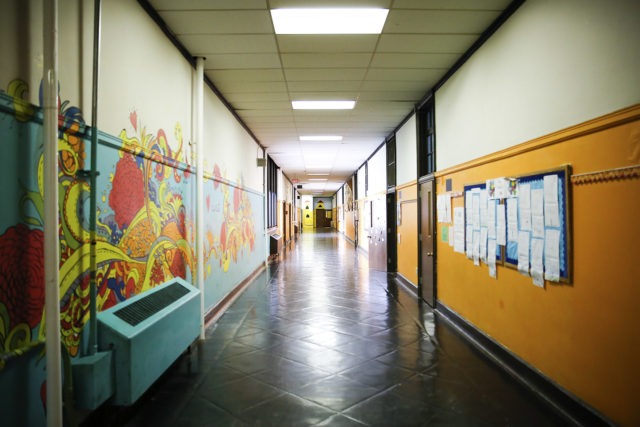 A school hallway with murals and bulletin boards.