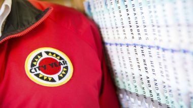 close up of AmeriCorps members' jacket, standing next to a row of books