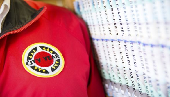 close up of AmeriCorps members' jacket, standing next to a row of books