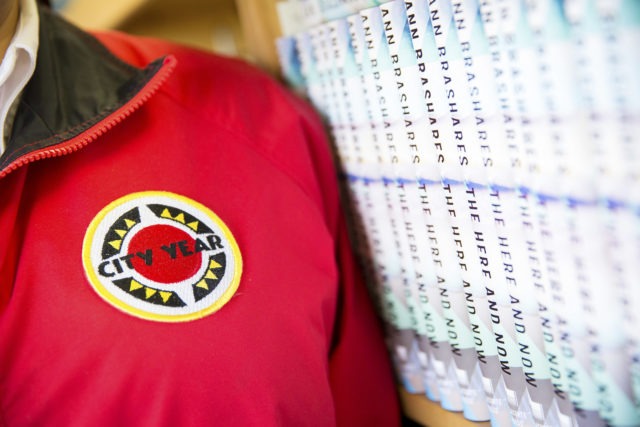 close up of AmeriCorps members' jacket, standing next to a row of books
