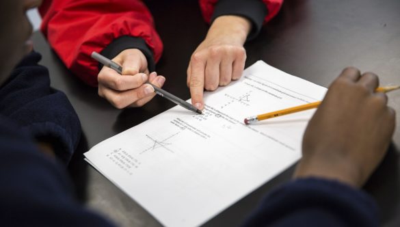 A student and AmeriCorps member working together on a math problem.