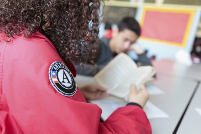 An AmeriCorps member and a student read a chapter book together.