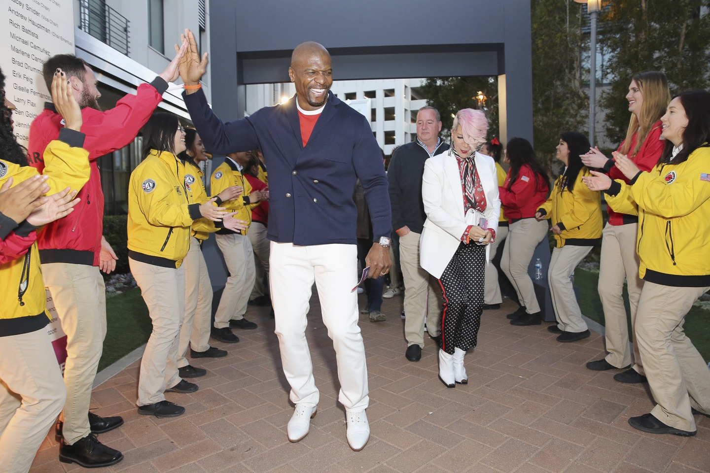 AmeriCorps members cheer as Terry Crews and other celebrities arrive at a City Year event