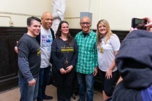 Five volunteers pose for and smile at the camera