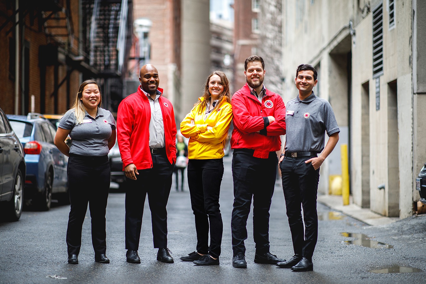 AmeriCorps members stand together in the street between city buildings.