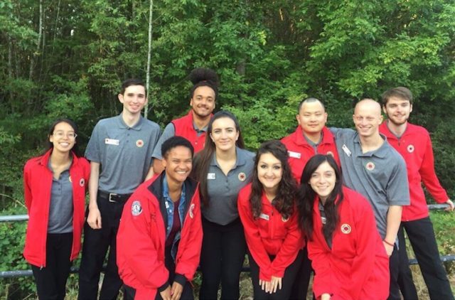 A team picure of ten AmeriCorps members in front of trees