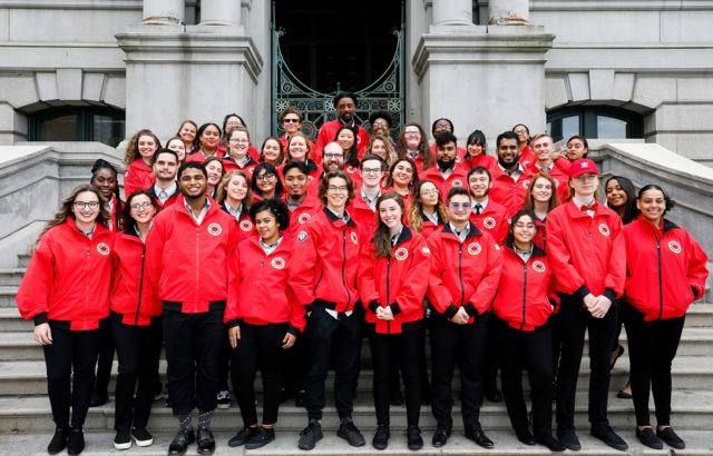 The City Year Providence corps stands on steps outside a stone building