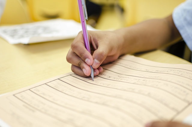 close up of student writing in a notebook