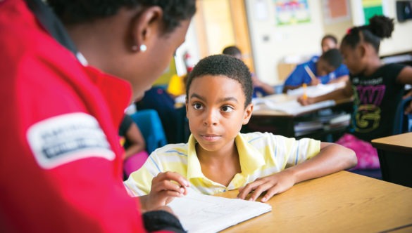 City Year AmeriCorps member tutoring an elementary student in a classroom
