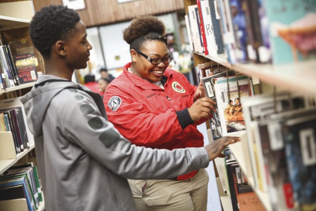 City Year AmeriCorps member in library with student