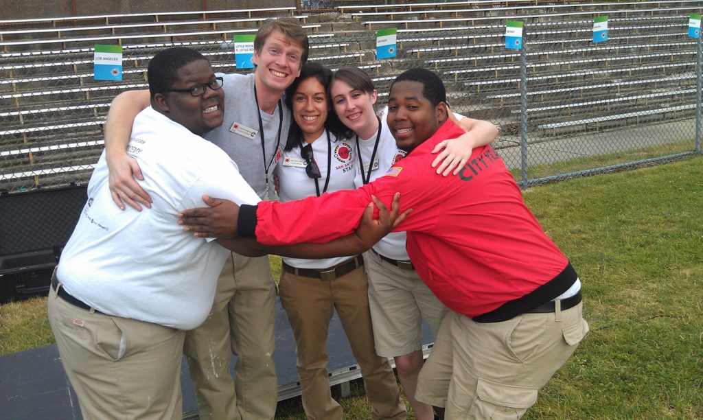 City Year Columbus alum Alen Amimi stands in a group hug with his teammates