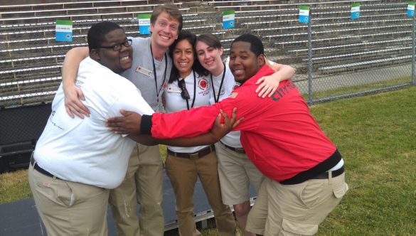 City Year Columbus alum Alen Amimi stands in a group hug with his teammates