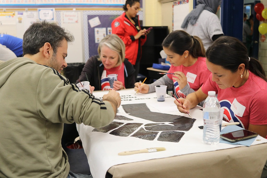 Volunteers painting canvas murals