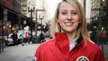 Emily Kean, former Senior Director of Impact Operations at City Year Chicago, in the iconic red jacket posing outside the office in Chicago, Illinois.