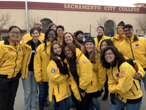 A groups of corps members pose in front of Sacramento City College