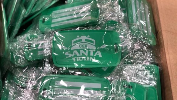 Green luggage tags wrapped in plastic with Santa Train and a CSX train logo on the front.