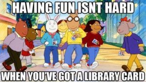 Arthur and his friends walk down the sidewalk with their library cards. The quote having fun isn't hard when you've got a library card runs across the top and bottom of the picture in white font with black outlines.