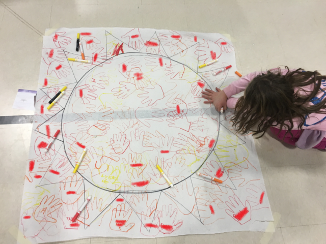 Students add their handprints to the sun at McDonough's literacy night