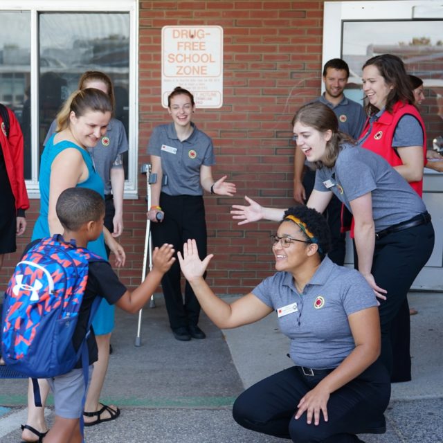 City Year corps members greet students on the first day of school