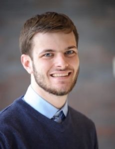 Headshot of Senior AmeriCorps Member Ben Carlin smiling in a navy sweater.