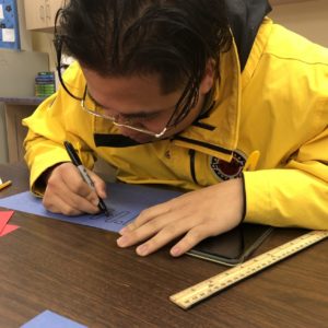 A city year americorps member colors on a piece of construction paper