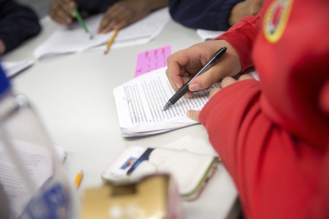 City Year AmeriCorps member tutoring students in ELA