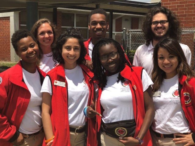 A group of smiling AmeriCorps members pose for a photo at a Duval County Public School.