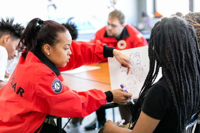 City Year AmeriCorps in school service red uniform