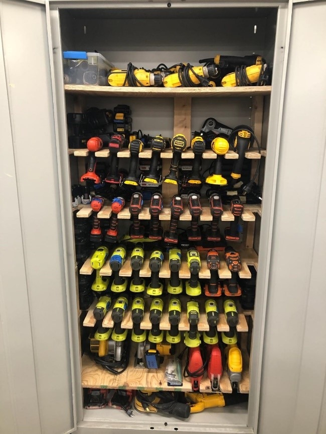 Open cabinet showing custom shelves for drills storage.