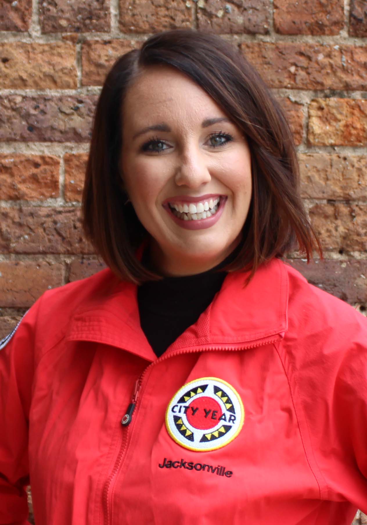 Allishia Bauman smiles as she wears her red City Year jacket