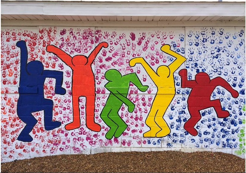 Care Force mural of five dancing silhouettes with handprints in the background