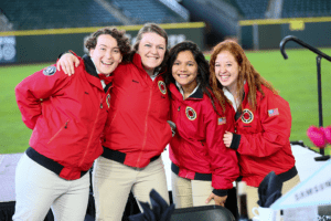 Four City Year Seattle / King County AmeriCorps members smiling at the camera in their red jackets