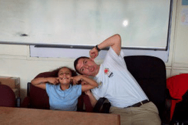 a City Year AmeriCorps member making silly faces with a student