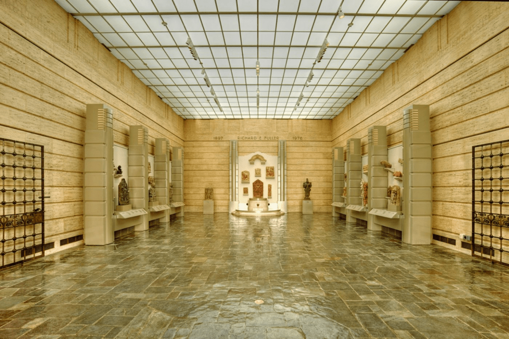 a tan room lined with sculpture exhibits at the Seattle Asian Art Museum