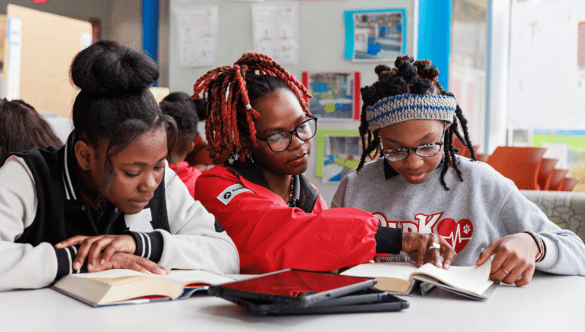 Two students read with a City Year Baton Rouge AmeriCorps member.