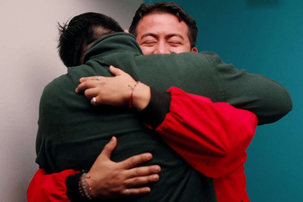 A City Year AmeriCorps member hugs the corps member who served them