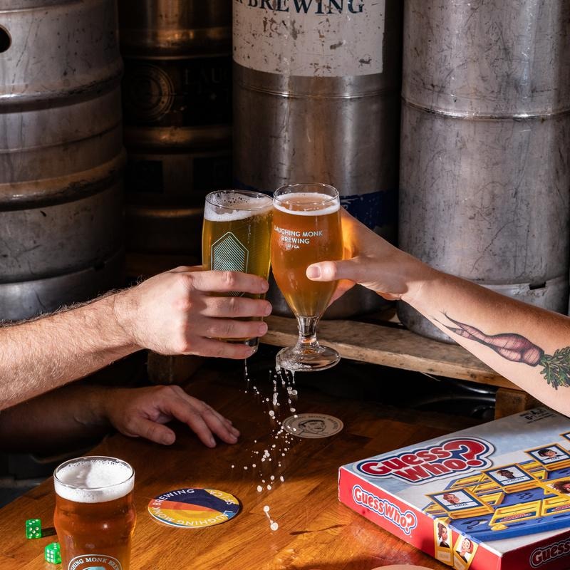 two hands clinking glasses full of beer
