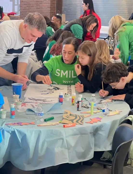Volunteers and kids working on craft projects at a table